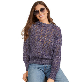 Frau lächelt in lila Pullover mit Rollkragen und Sonnenbrille vor neutralem Hintergrund.