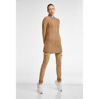 Frau in einem langen, beigefarbenen Pullover aus Wool-Cotton, kombiniert mit weißen Sneakers.