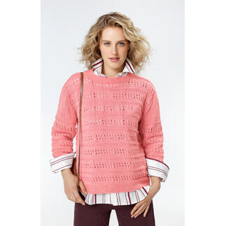 Frau in einem rosa Pullover mit Lochmuster, kombiniert mit Hemd und Tasche.