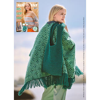Frau mit Poncho und Tasche aus Nappy, vor einer hellen Landschaft.
