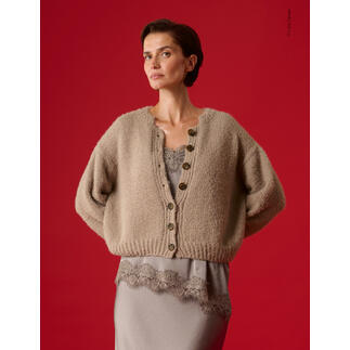 Beige Jacke aus Cosi mit Knöpfen, Modell steht vor rotem Hintergrund.