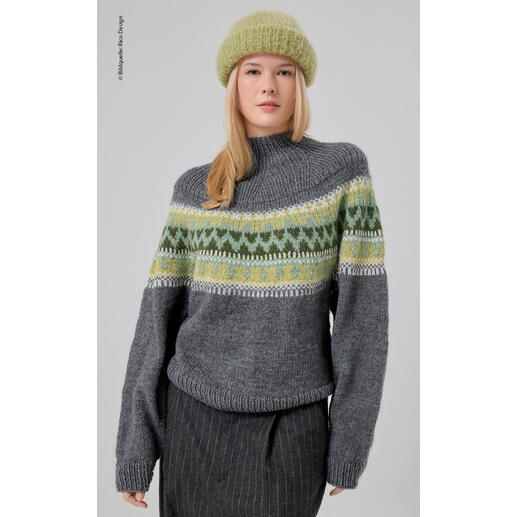 Frau in grauem Pullover mit grünem Muster, trägt einen grauen Hut.