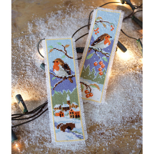 Zwei Lesezeichen mit Rotkehlchen auf winterlichem Hintergrund und Lichtern.