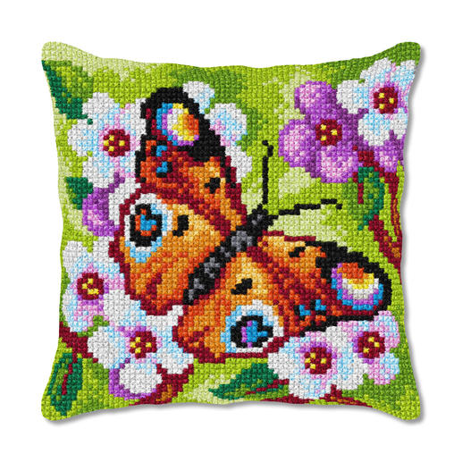 Kreuzstichkissen mit Tagpfauenauge auf buntem Blumenmuster.
