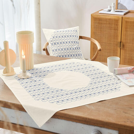 Sashiko-Tischdecke in Creme mit blauen stitch-Mustern auf einem Holztisch.