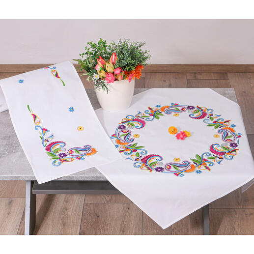 Tischwäsche mit Paisleymuster und Blumen, auf einem Tisch mit Dekoration.