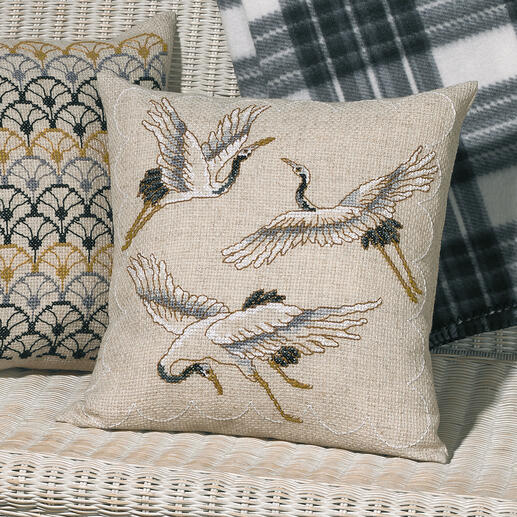 Kissenhülle mit Kranichen, auf beigem Hintergrund kunstvoll gestickt.