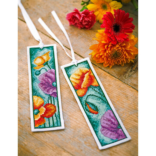 Zwei Lesezeichen mit Mohnblumenmotiven auf einem Holztisch.