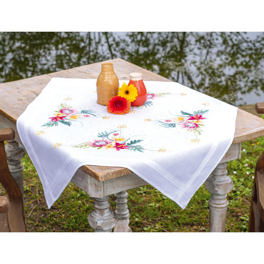 Tischwäsche mit buntem tropischem Blumenmuster auf einem Holztisch.