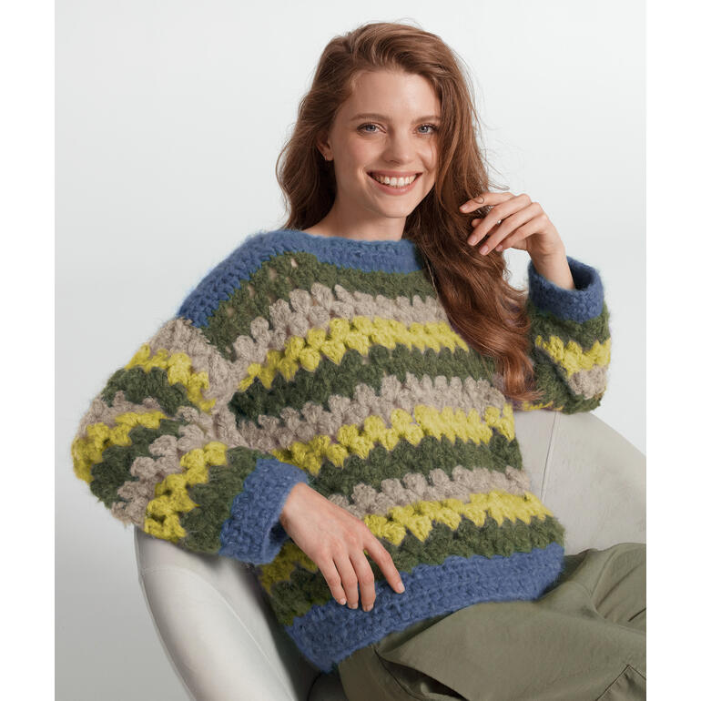 Bunter Häkelpullover von Junghans-Wolle, weibliches Model lächelt.
