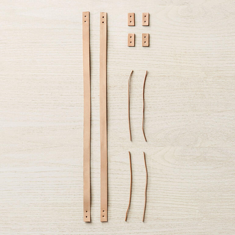 Lederhenkel-Set von Coco Knits, auf einem hellen Hintergrund ausgebreitet.