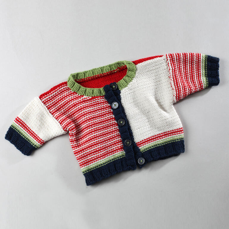 Gestreifte Babyjacke in Rot, Grün und Weiß mit Knöpfen, auf grauem Untergrund.