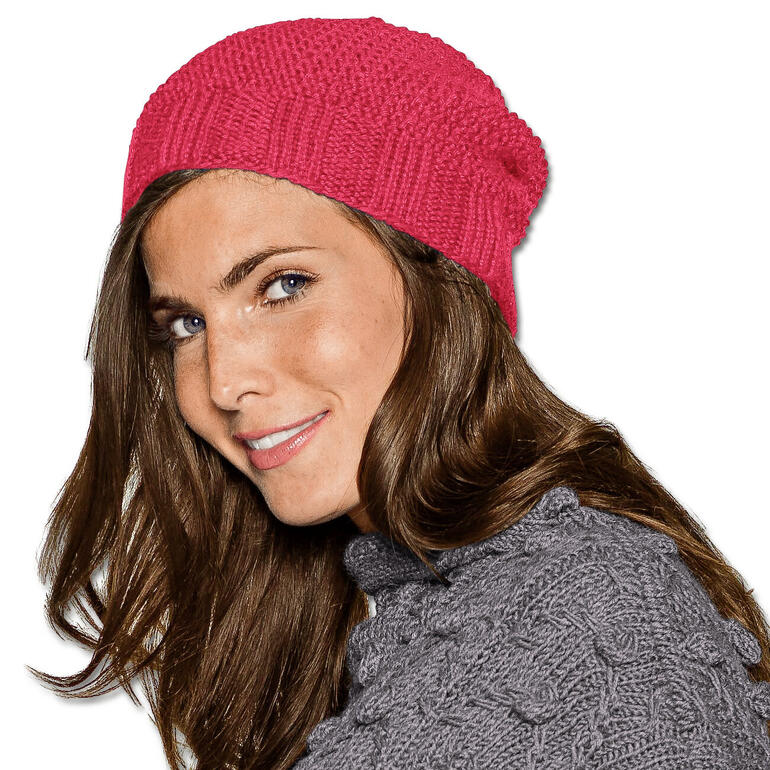 Frau trägt eine pinke Mütze aus Peruwolle.