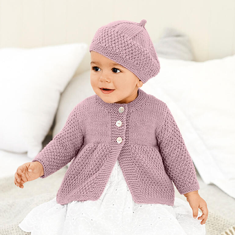 Kleines Kind trägt einen Baby-Mantel mit Mütze in Rosa