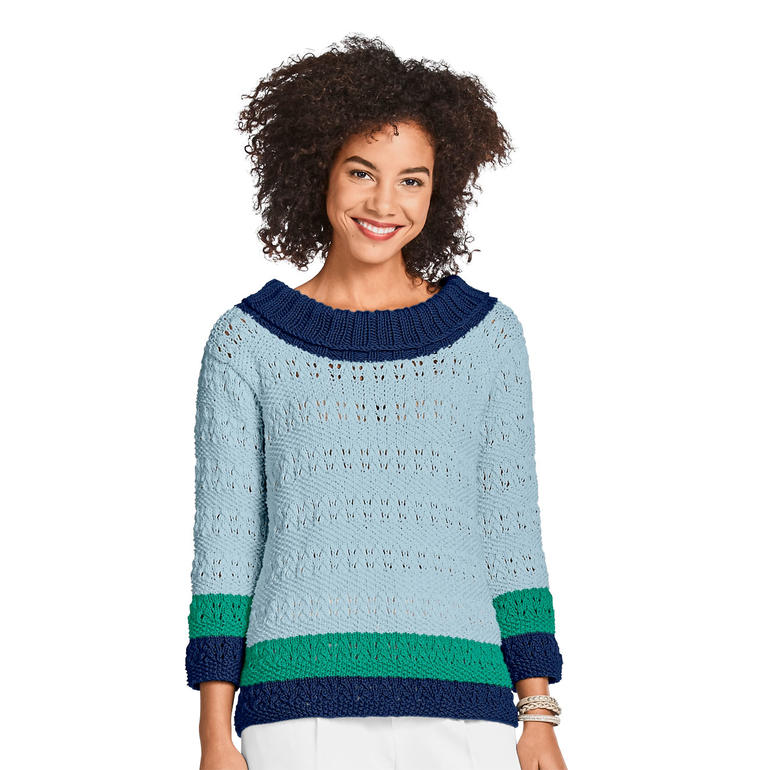 Dame lächelt in einem hellblauen Damenpullover aus Cotonara mit modernen Mustern.