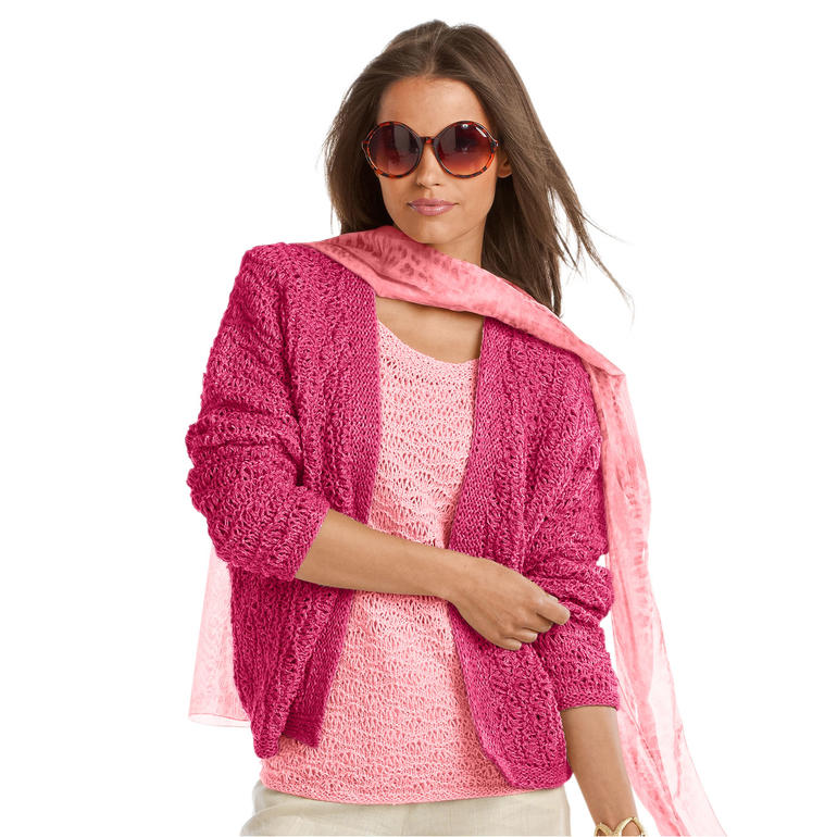 Frau in pinkem Twinset mit Sonnenbrille und schal, vor neutralem Hintergrund.