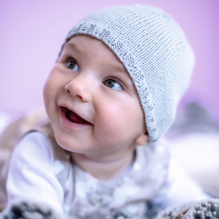 Baby mit blauer Mütze aus Baby Smiles Cotton Bamboo.