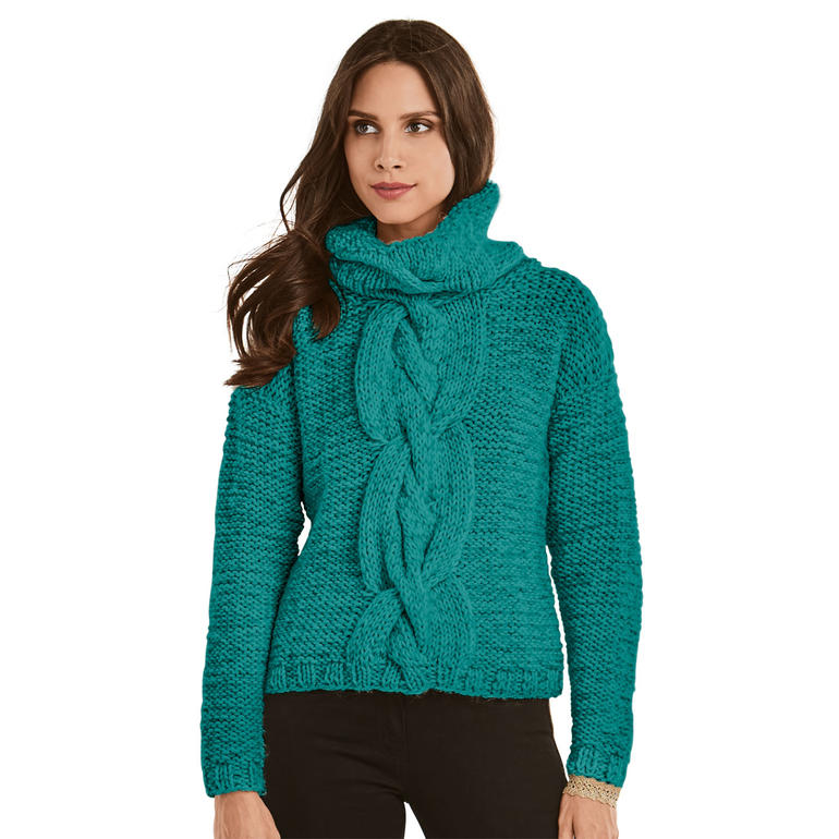 Frau in turkisfarbener Strickjacke mit dicker Strickstruktur und Zöpfen, schaut in die Kamera.