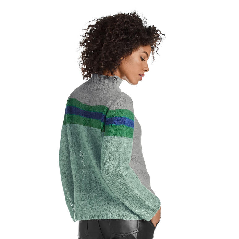 Dame in grauem Pullover aus Aerea, hebt den Kopf leicht.