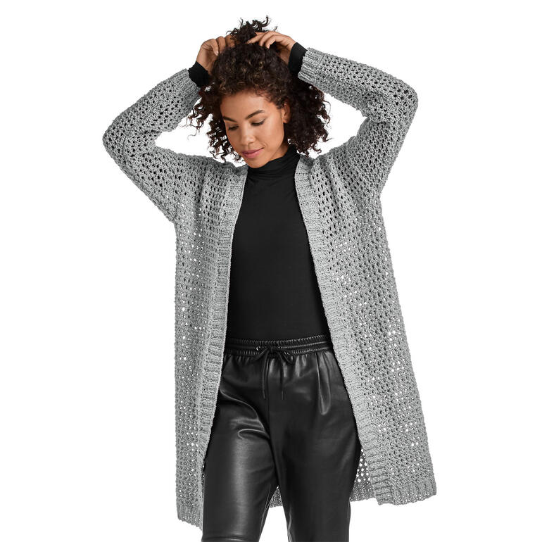 Grauer Mantel, lässig getragen von Frau mit lockigen Haaren.