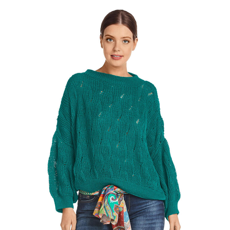 Türkiser Pulli mit Muster, elegant getragen von Frau mit Sonnenbrille.