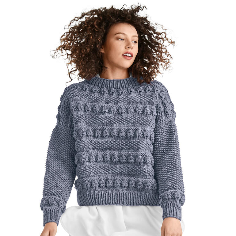 Pullover aus Merino Dick in hellblau mit Struktur, auf einer Frau stehend.