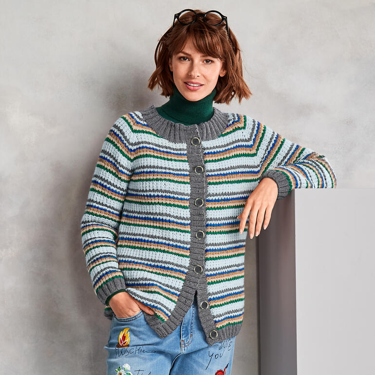 Frau trägt eine gestreifte Jacke aus Monello-175 Uni, lächelt und hat die Hände in die Hüften gestützt.