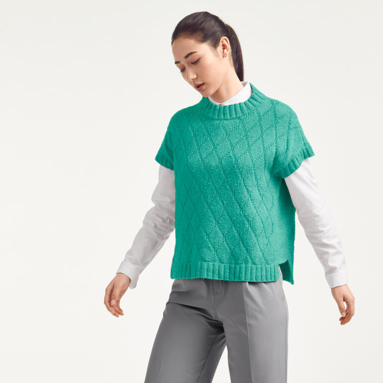 Frau in türkisfarbenem Pullunder aus Recycle & Wool mit modernen Schnitt.