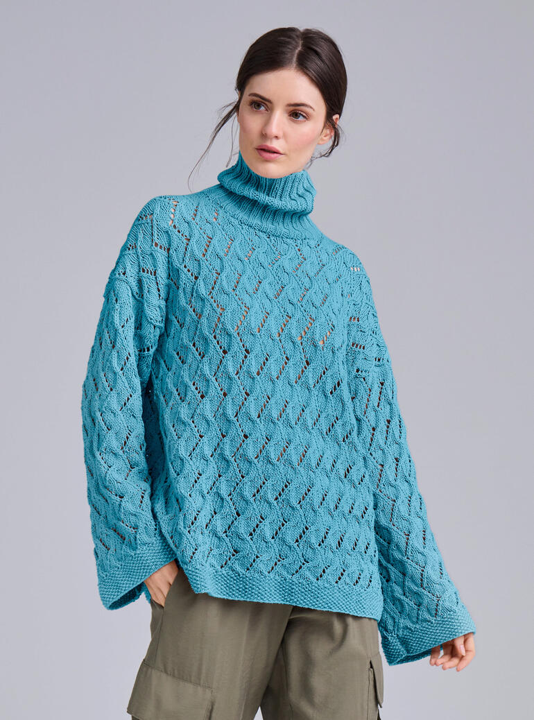 Pullover aus Cotonia-Mezzo in Türkis mit Lochmuster, getragen von einer Frau.