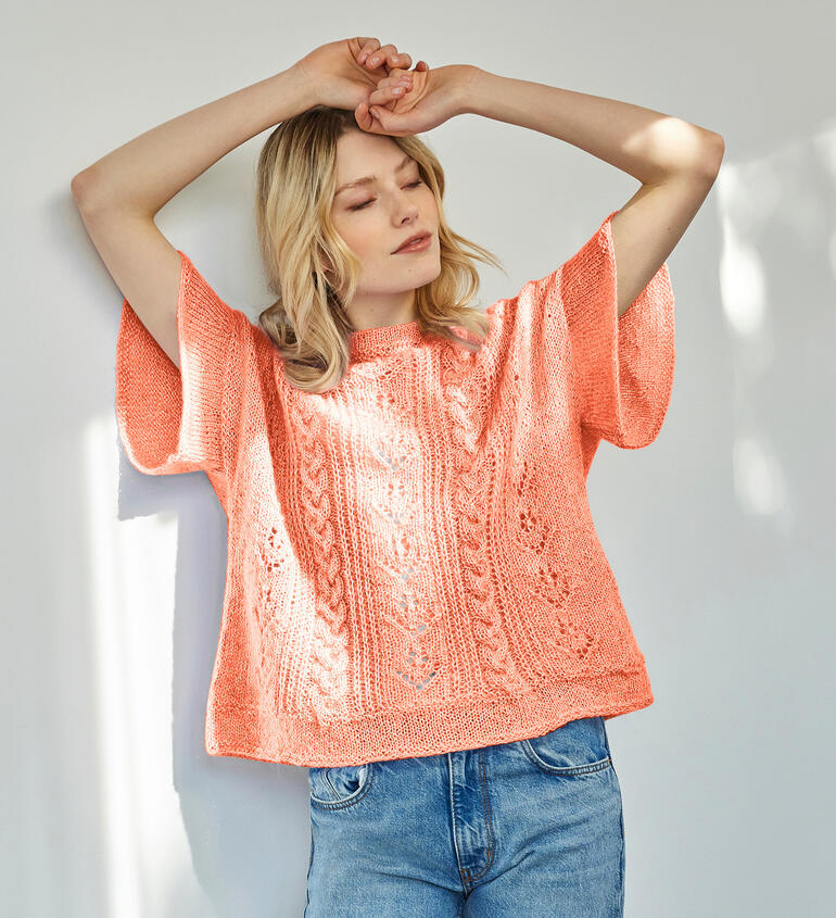 Korallenfarbener Pullover mit lockeren Ärmeln und großzügigem Schnitt.
