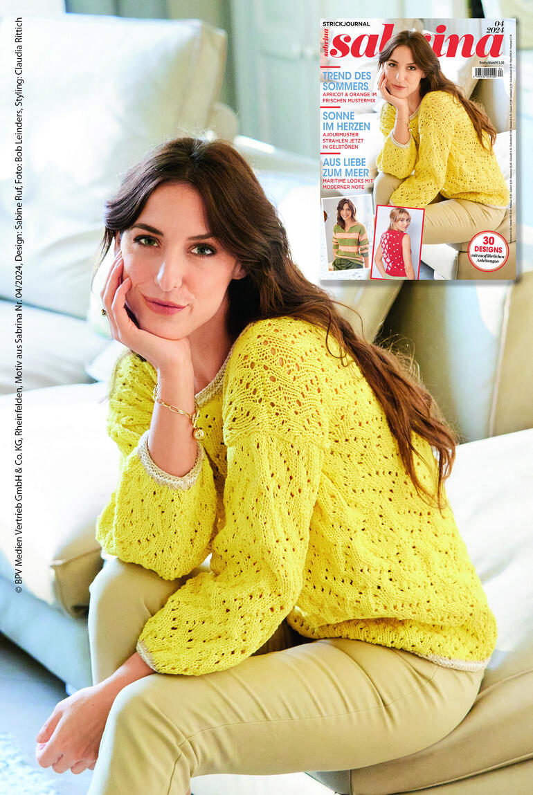 Frau in gelbem Lochmustervpullover sitzt auf einem Sofa.