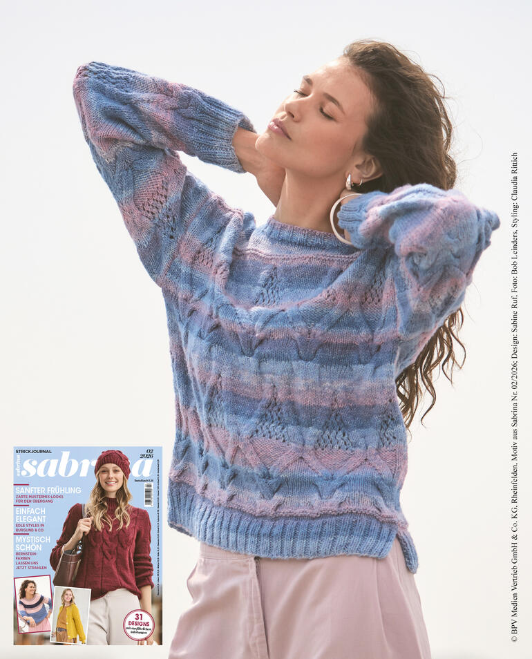 Frau in Pullover mit Zopfmuster, träumt unter freiem Himmel.