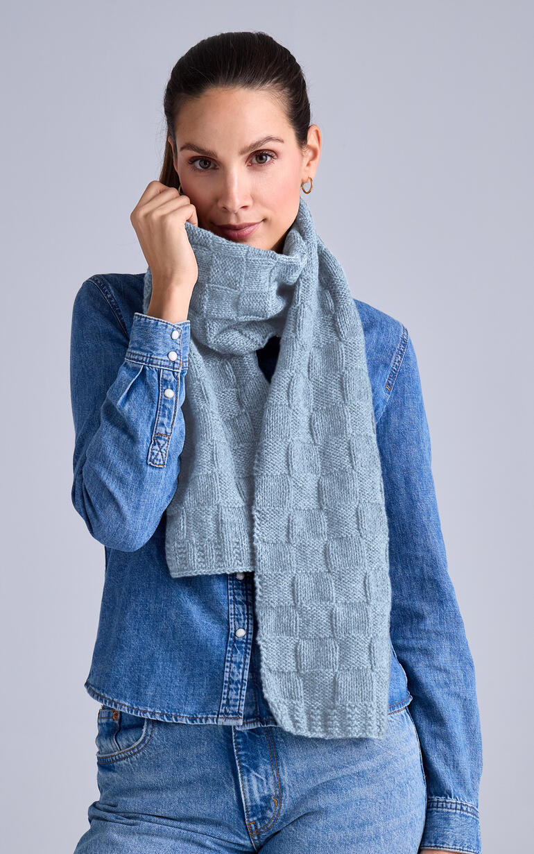 Frau hält einen hellblauen Schal aus Wool-Cashmere vor sich.