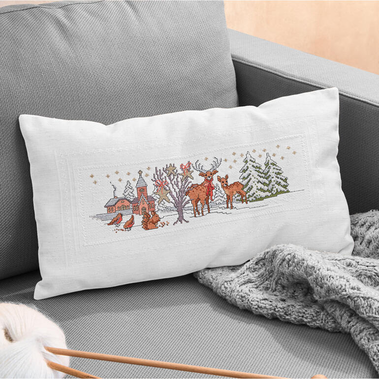 Kissenhülle mit winterlichen Tieren und einer verschneiten Landschaft