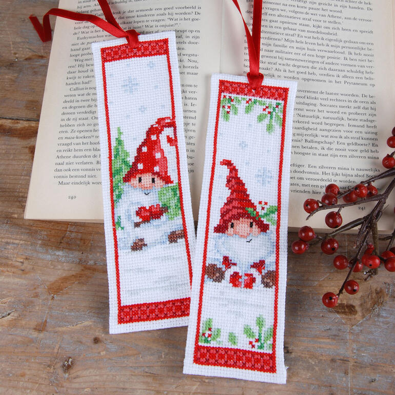 Zwei Lesezeichen mit Wichtelmotiven, verziert mit roten Bändern.