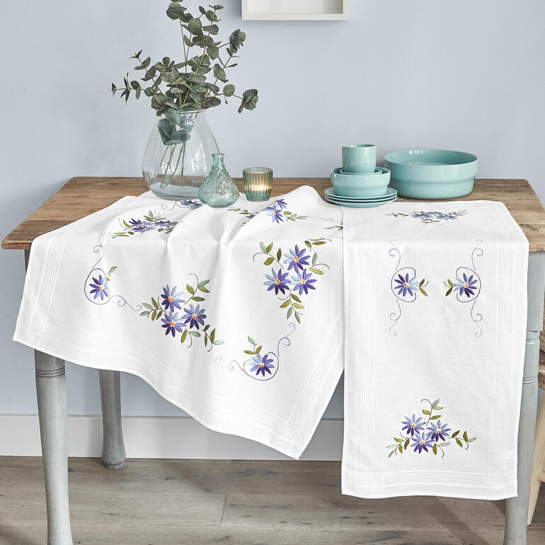 Tischläufer mit blauem Sternenstickerei und Vasen auf einem Tisch