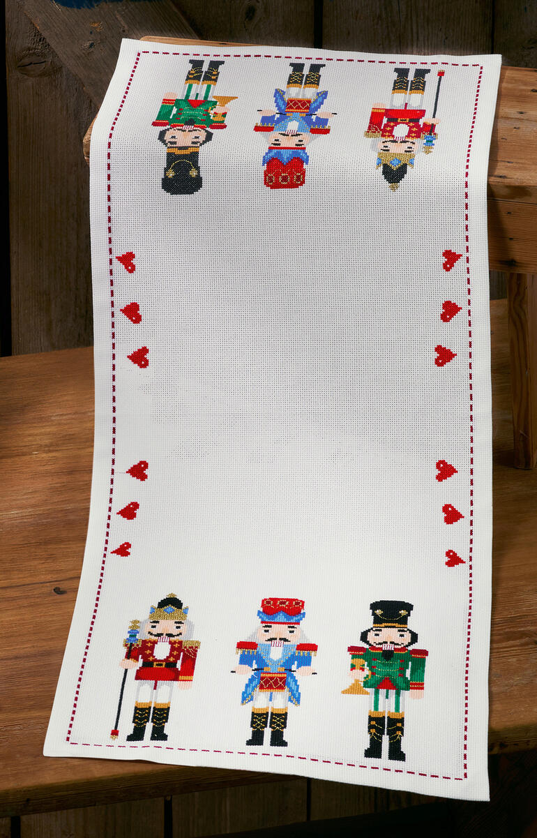Tischläufer mit bunten Nussknacker-Motiven und Herzen.