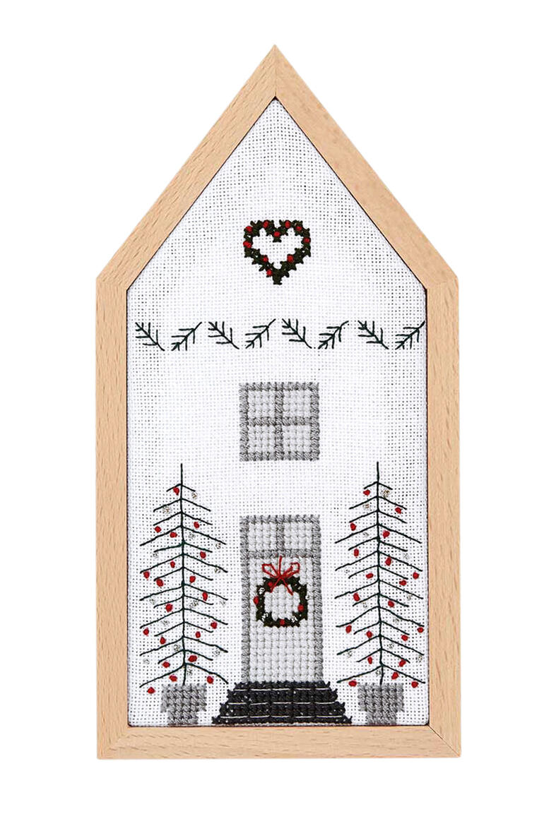 Kreuzstichbild eines weißen Hauses mit Weihnachtsbaum und Herz auf dem Dach
