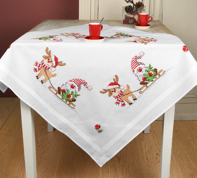 Weihnachtstischdecke mit einem Wichtel und Rentier, die fröhlich auf einem Tisch sitzen.