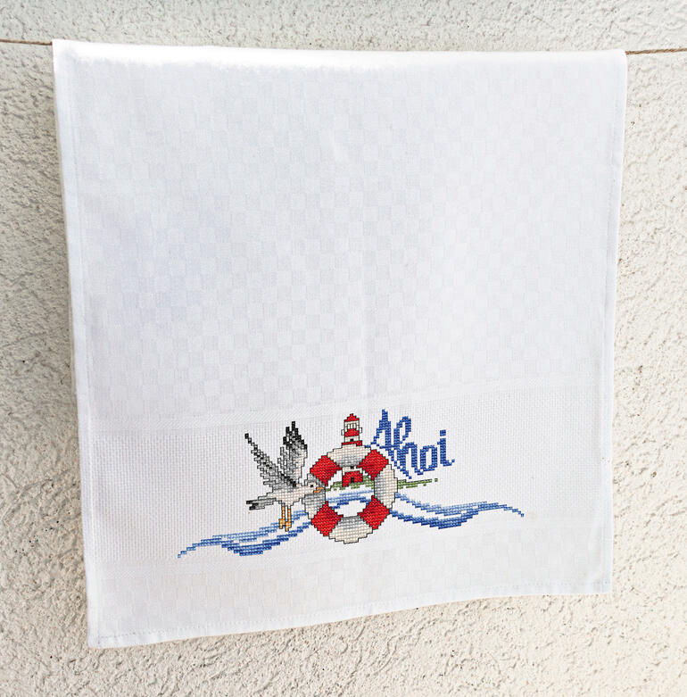 Geschirrtuch mit maritimen Motiven und 'Ahoi'.
